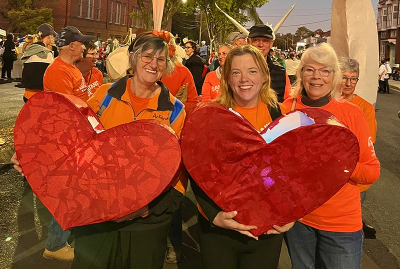 Haylie Campbell with Samaritan’s Purse volunteers holding red hearts in Lismore, NSW